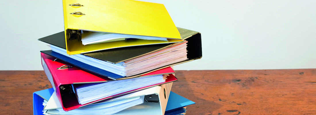 Stack of coloured file binders on top of each other.