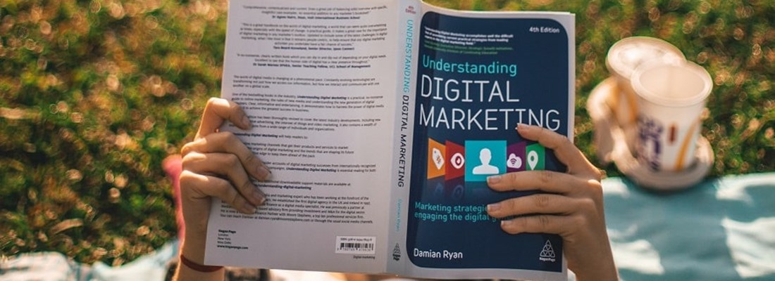 Women reading a book called Understanding Digital Marketing.