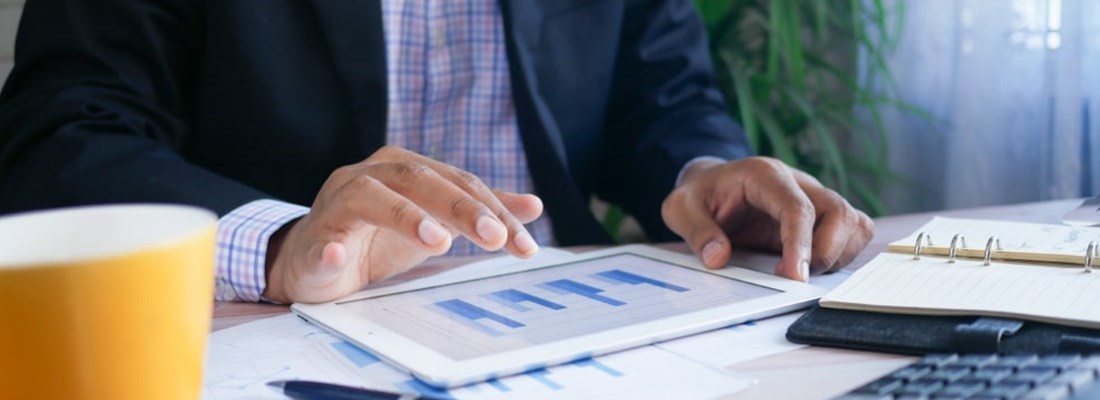 Person looking at tablet with data graph shown on the screen.